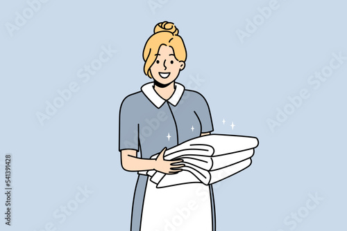 Smiling housekeeper in uniform holding stack of towels. Happy female housemaid or janitor working in hotel. Housekeeping concept. Vector illustration. 