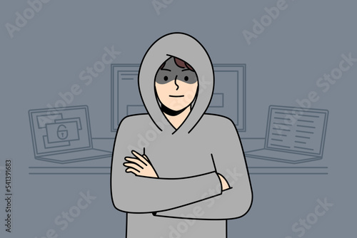 Slika na platnu Young man in hood standing near computers hacking internal operations system