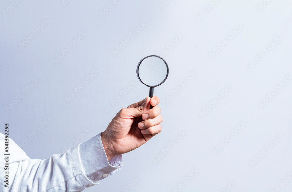 Man hand holding magnifying glass on white background. Hand holding magnifying glass looking for something with space for text, Hand holding magnifying glass on isolated background Man hand holding magnifying glass on white background. Hand holding magnifying glass looking for something with space for text, Hand holding magnifying glass on isolated background