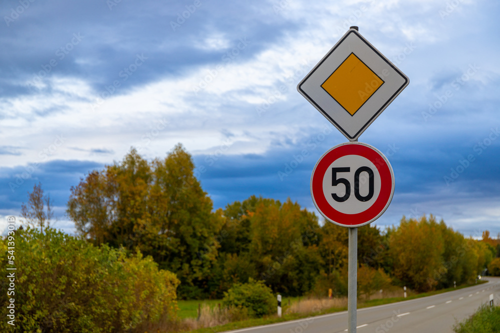 road sign with 50 kmh and right of way, Germany in autumn