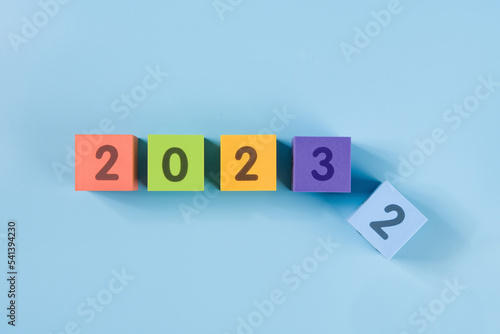 Flipping wooden cubes for new year change 2022 to 2023. New year change and starting concept.