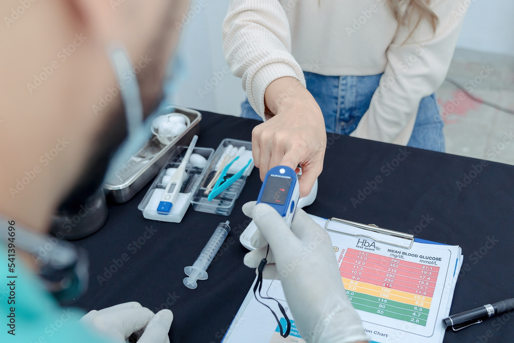Doctor checking oxygenation with fingertip pulse oximeter. Saturation blood of oxygen. Measuring the patient's blood saturation with an oximeter Doctor checking oxygenation with fingertip pulse oximeter. Saturation blood of oxygen. Measuring the patient's blood saturation with an oximeter