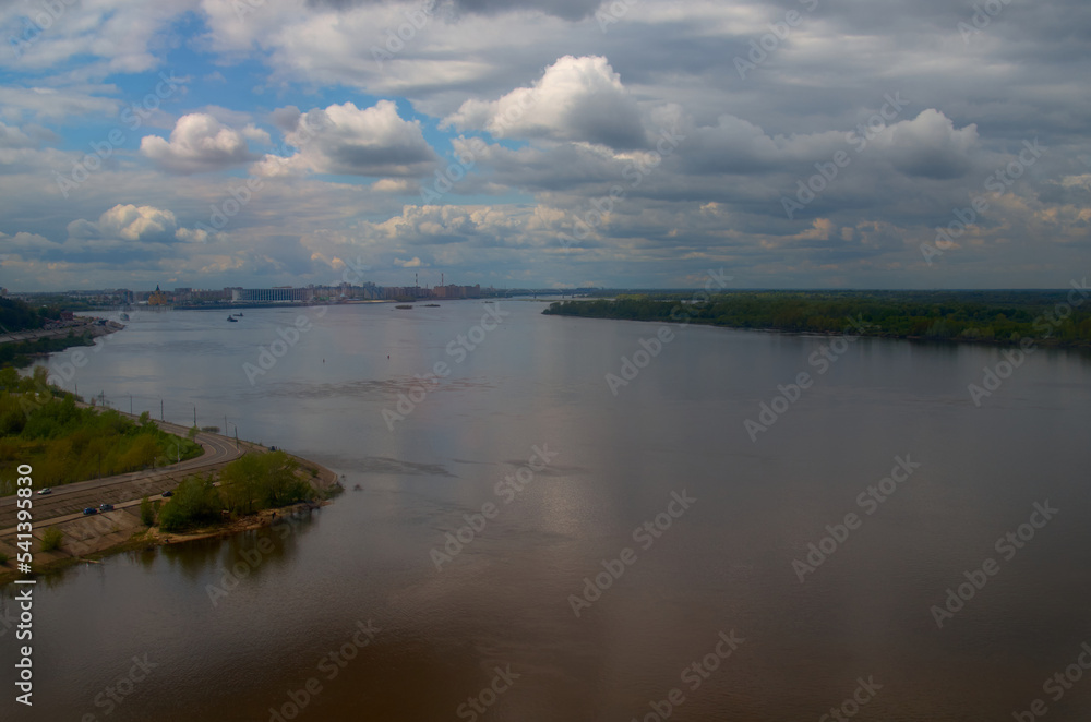 River water landscape. Blue sky with clouds and city on the background