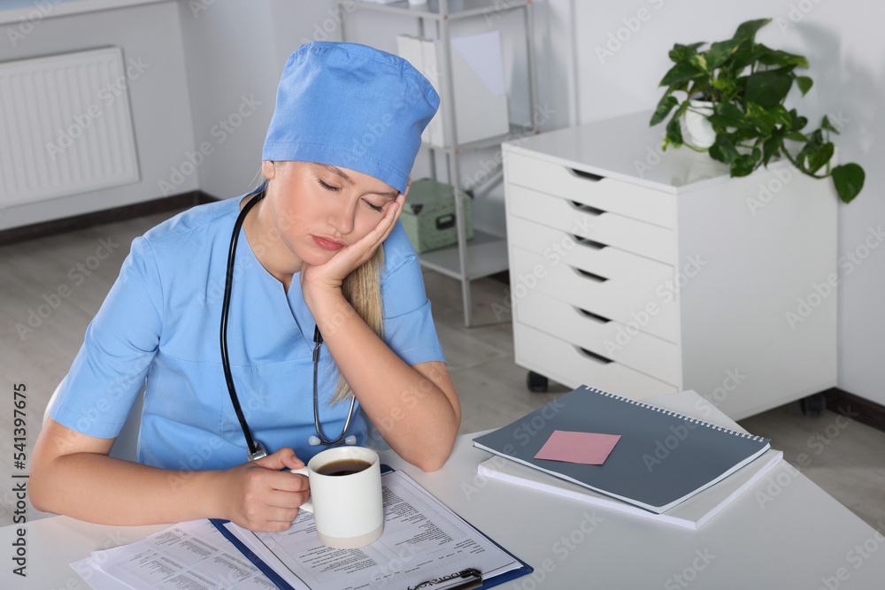 Tired young doctor sleeping at workplace in office Tired young doctor sleeping at workplace in office
