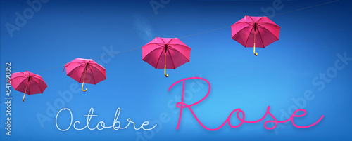 Octobre rose, parapluie rose dans le ciel bleu, concept bannière photo