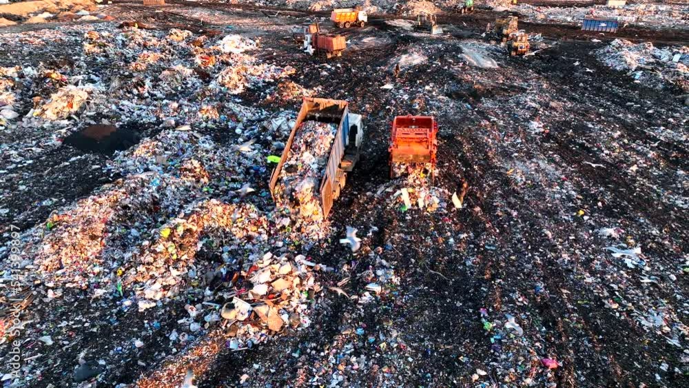 Garbage truck unloads rubbish in landfill. Landfill waste disposal. Garbage dump with waste
