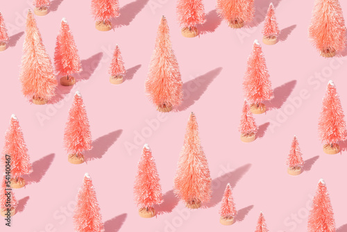 Christmas creative pattern with pink christmas trees on pastel pink background.  New Year celebration creative idea. Retro aesthetic minimal concept .