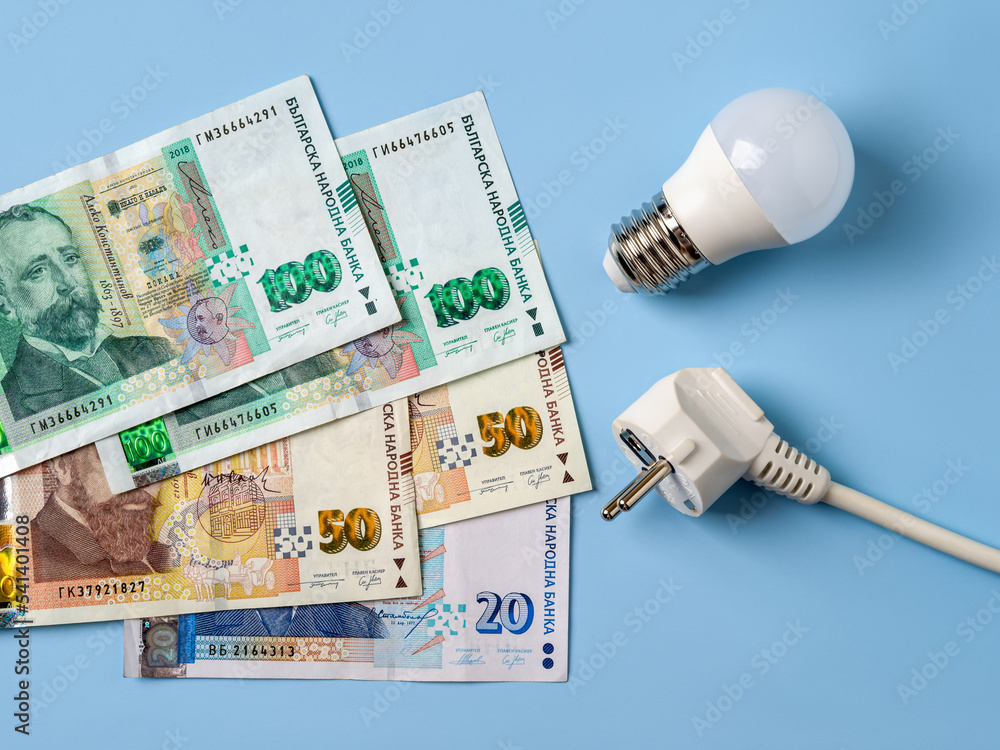 Electric plug, light bulb and over blue background. Increasing of electricity costs in Bulgaria. Power crisis, expensive energy bills, rise in electricity prices concept. Electric plug, light bulb and over blue background. Increasing of electricity costs in Bulgaria. Power crisis, expensive energy bills, rise in electricity prices concept.