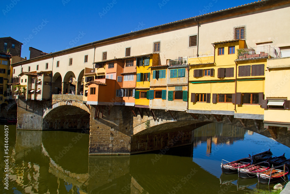 Arch bridge, the Ponte Vecchio in Florence, houses reflected in flowing water Arch bridge, the Ponte Vecchio in Florence, houses reflected in flowing water