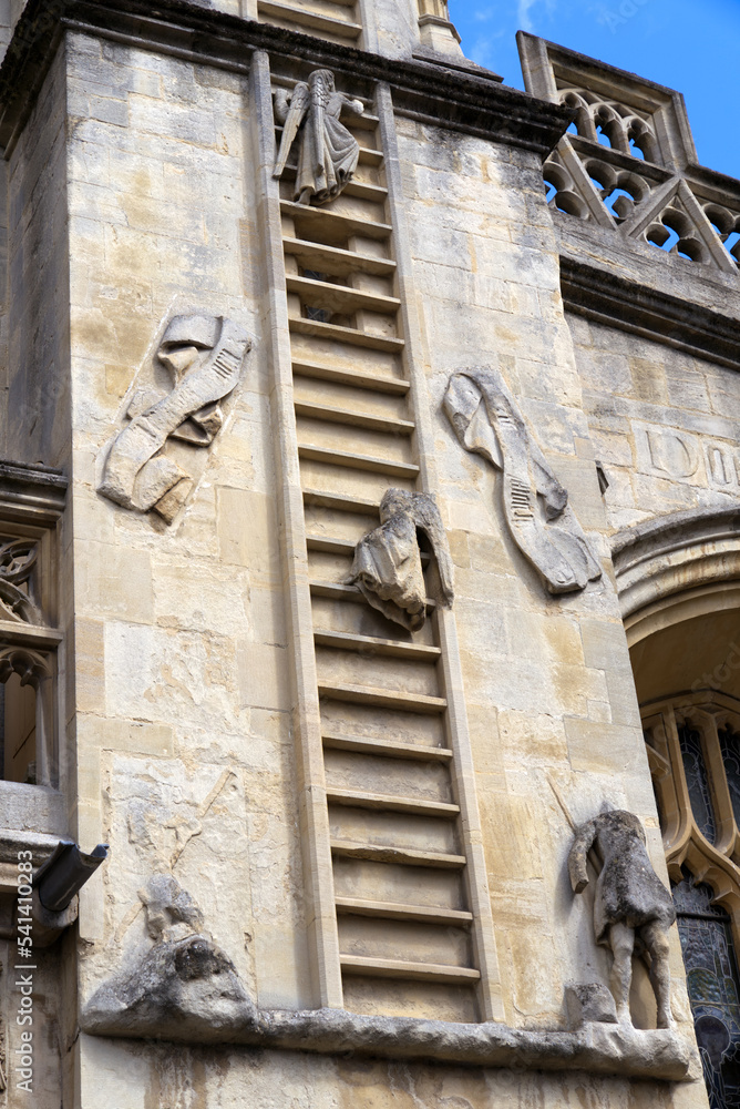 Main entrance of famous Abbey Church of Saint Peter and Saint Paul at City of Bath with angels climbing ladder on a blue cloudy summer day. Photo taken August 2nd, 2022, Bath, United Kingdom.