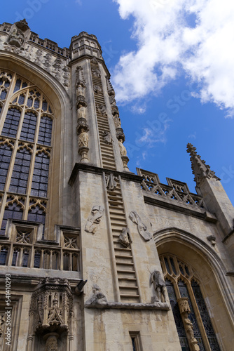 Main entrance of famous Abbey Church of Saint Peter and Saint Paul at City of Bath with angels climbing ladder on a blue cloudy summer day. Photo taken August 2nd, 2022, Bath, United Kingdom. © Michael Derrer Fuchs