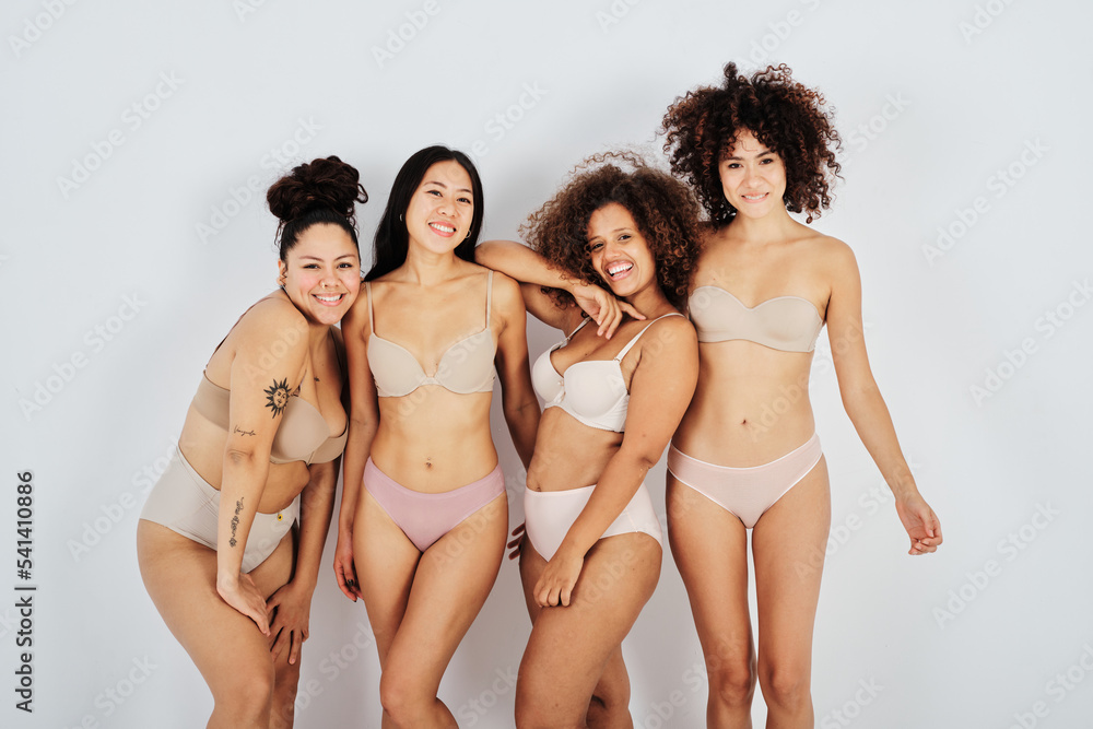Group of happy multiethnic body positive ladies smiling at camera