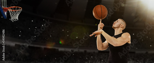 Young professional basketball player spin thr ball on finger at basketball court with people fans. Photoreal 3d render of sport arena.