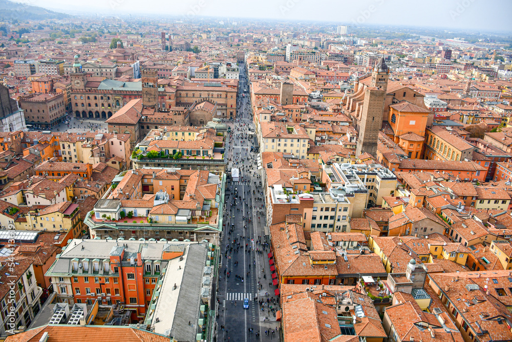 Obraz premium Aerial Cityscape view from the tower Asinelli on Bologna old town center with Maggiore square in Italy.Colorful sky over the historical city center with car traffic and old buildings