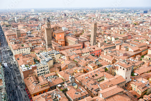 Aerial Cityscape view from the tower Asinelli on Bologna old town center with Maggiore square in Italy.Colorful sky over the historical city center with car traffic and old buildings