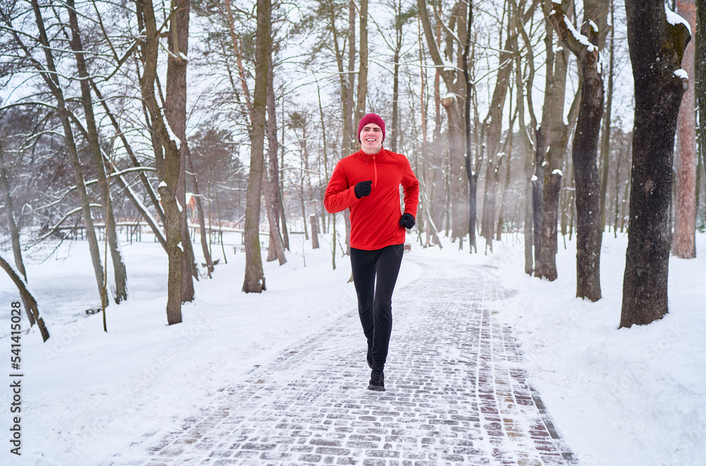 Healthy lifestyle. Jogging outdoors. Young strong man is running at snowy park. Healthy lifestyle. Jogging outdoors. Young strong man is running at snowy park.