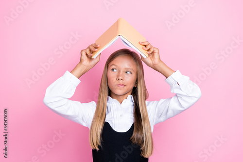 Photo of unsure schoolkid hold textbook above head try find materials project isolated on pastel color background