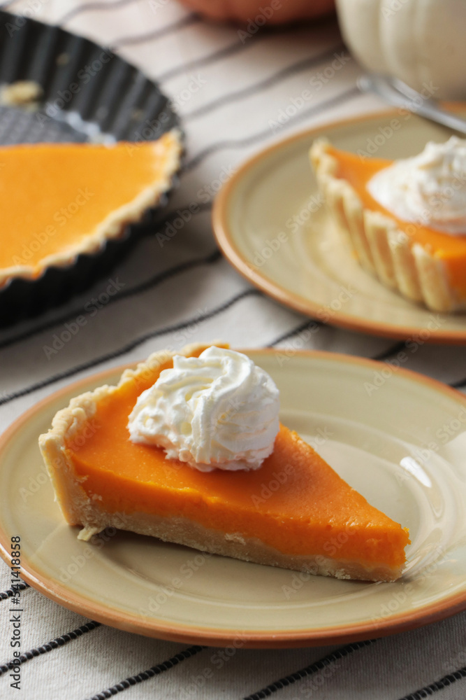 Fresh homemade pumpkin pie with whipped cream on table Fresh homemade pumpkin pie with whipped cream on table