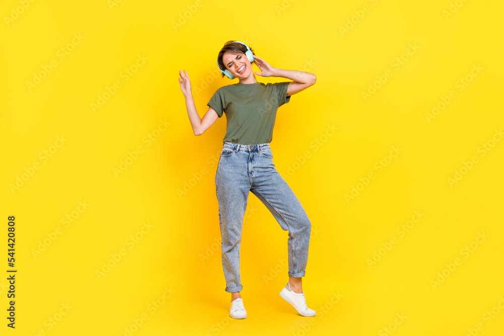 Full length photo of pretty positive lady music lover dressed stylish clothes free time playlist isolated on yellow color background Full length photo of pretty positive lady music lover dressed stylish clothes free time playlist isolated on yellow color background