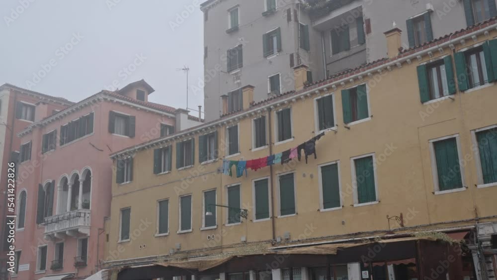 Slow motion on a yellow building with clothes hanging out to dry in the mist of a wet day in Venice Italy. Moody foggy day. Slow motion on a yellow building with clothes hanging out to dry in the mist of a wet day in Venice Italy. Moody foggy day.