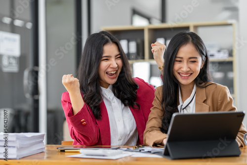 Two young businesswomen are delighted to be successful in online business. and had a huge income.