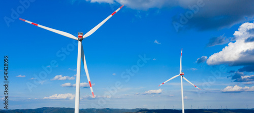 a modern wind turbine park panorama in front of a blue sky
