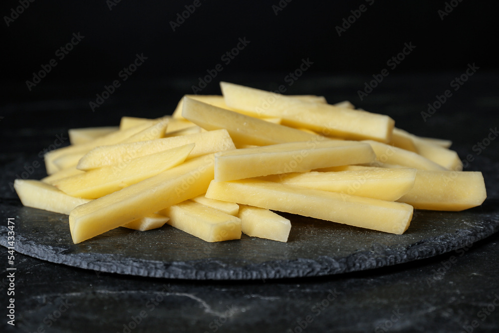 Cut raw potatoes on black table, closeup Cut raw potatoes on black table, closeup