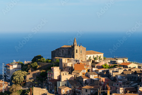 View of the Holy Trinity Church and the Augustinian Monastery. In the distance, the Mediterranean Sea and the cloudless sky. Sicily. Forze d 'Agro