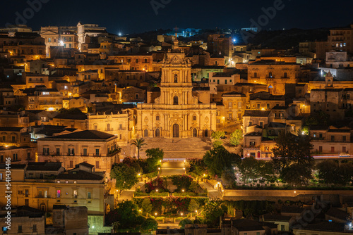 Night photo from the viewpoint of the old town of Modica. Widko is attracted by the Cathedral of St. George. Illuminated buildings all around. Sicily. Italy