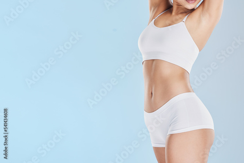 Schilderij op canvas Fitness, lingerie and body of a woman with health, training and cosmetics against blue mockup studio background