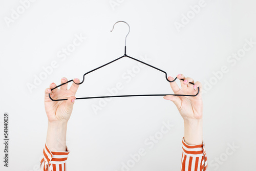 Minimal Fashion stylist or buyer concept, nothing to wear, cloth hanger and woman hand photo