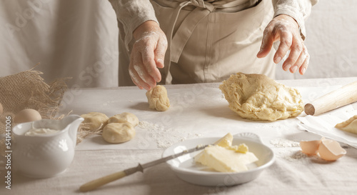 Women’s hands, flour and dough. A woman is preparing a dough for home baking. Concept of home cooking with organic and natural ingredients. Zero waste concept