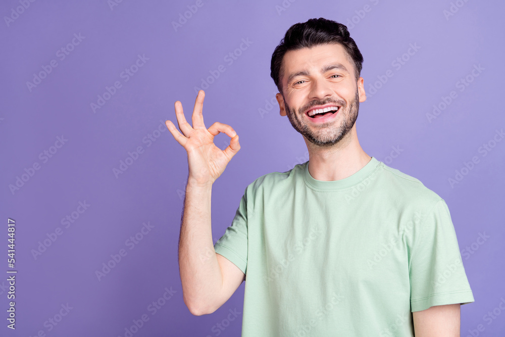 Photo of cheerful man trendy clothes hand arm demonstrate good job symbol satisfied haircut empty space isolated on purple color background Photo of cheerful man trendy clothes hand arm demonstrate good job symbol satisfied haircut empty space isolated on purple color background