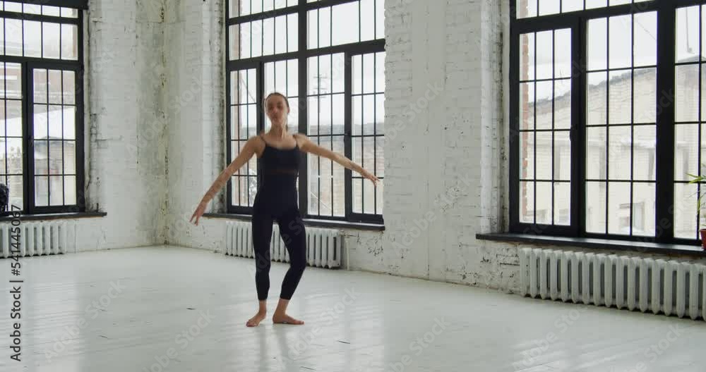 Modern female dancer in black outfit practices in a dance studio Modern female dancer in black outfit practices in a dance studio