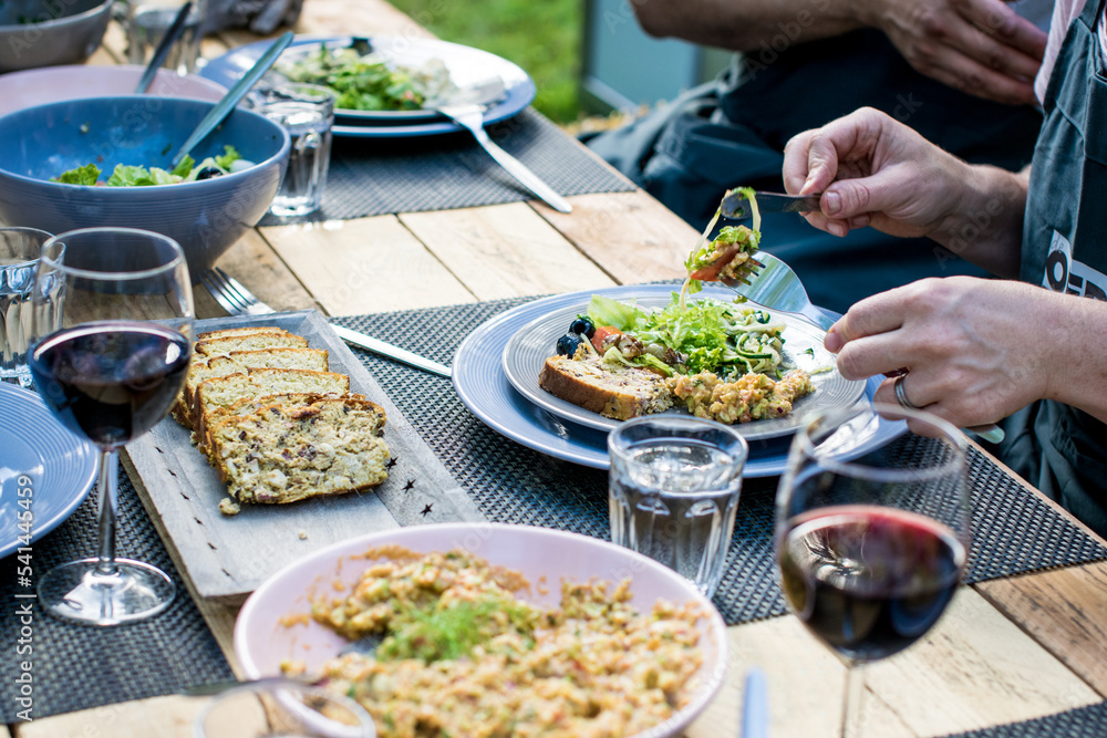 BBQ Outdoor with food preparations. People eating and dining outdoor. Lots of vegetables, fish, and meat. BBQ Outdoor with food preparations. People eating and dining outdoor. Lots of vegetables, fish, and meat.