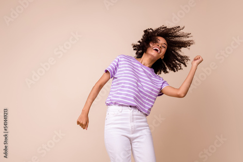 Photo of pretty funky lady wear violet t-shirt having fun dancing empty space isolated beige color background