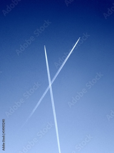 Flugzeug mit Kondensstreifen hoch am Himmel
