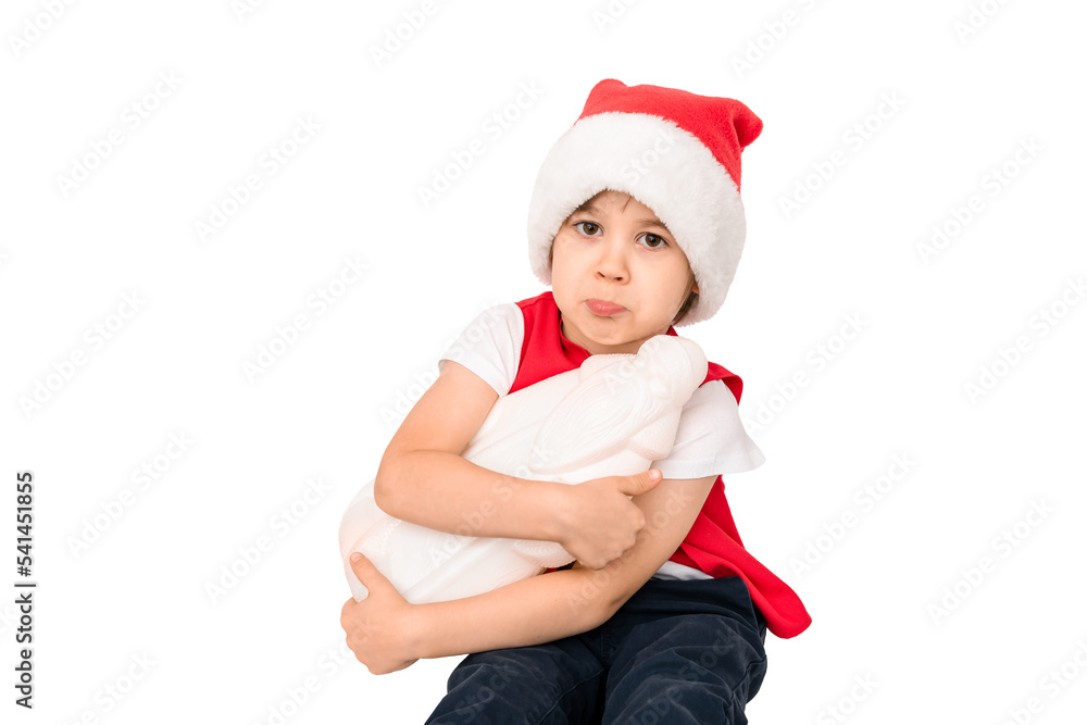 Portrait of unhappy resentful little child in red Santa Claus hat isolated on white background. Beautiful five-year European boy. Bad gift. Copy space. Merry Christmas. Bad mood. Close-up. New Year Portrait of unhappy resentful little child in red Santa Claus hat isolated on white background. Beautiful five-year European boy. Bad gift. Copy space. Merry Christmas. Bad mood. Close-up. New Year