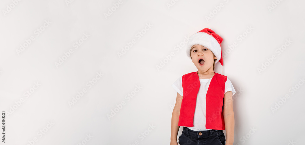 Portrait of singing boy in red Santa Claus hat isolated on white background. Cute 5 year singer child. Copy space. Banner. Concept of holiday music. Creative hobby. Sing lessons gift certificate. Wow Portrait of singing boy in red Santa Claus hat isolated on white background. Cute 5 year singer child. Copy space. Banner. Concept of holiday music. Creative hobby. Sing lessons gift certificate. Wow