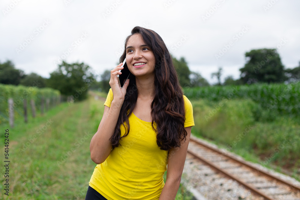 Content young ethnic having phone call in nature 