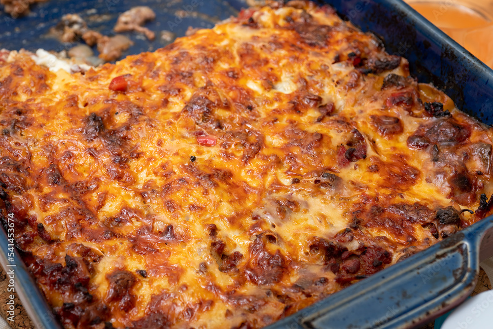 Close-up of a freshly baked meat lasagne with brown topping in a baking dish. Selective focus. Close-up of a freshly baked meat lasagne with brown topping in a baking dish. Selective focus.