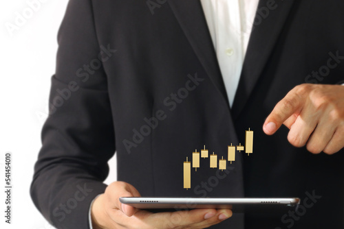 Businessman points finger to 3d rendering Golden Candlestick bar chart showing growth of business, monitors stock market looking financial data, analyzing trend. Stocks, Cryptocurrency, forex concept.