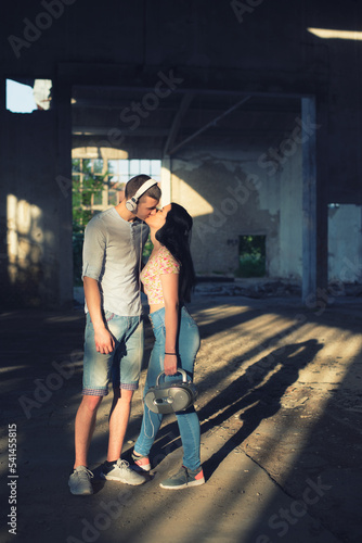 Young teenage couple kissing in an abandoned building on a sunny summer day