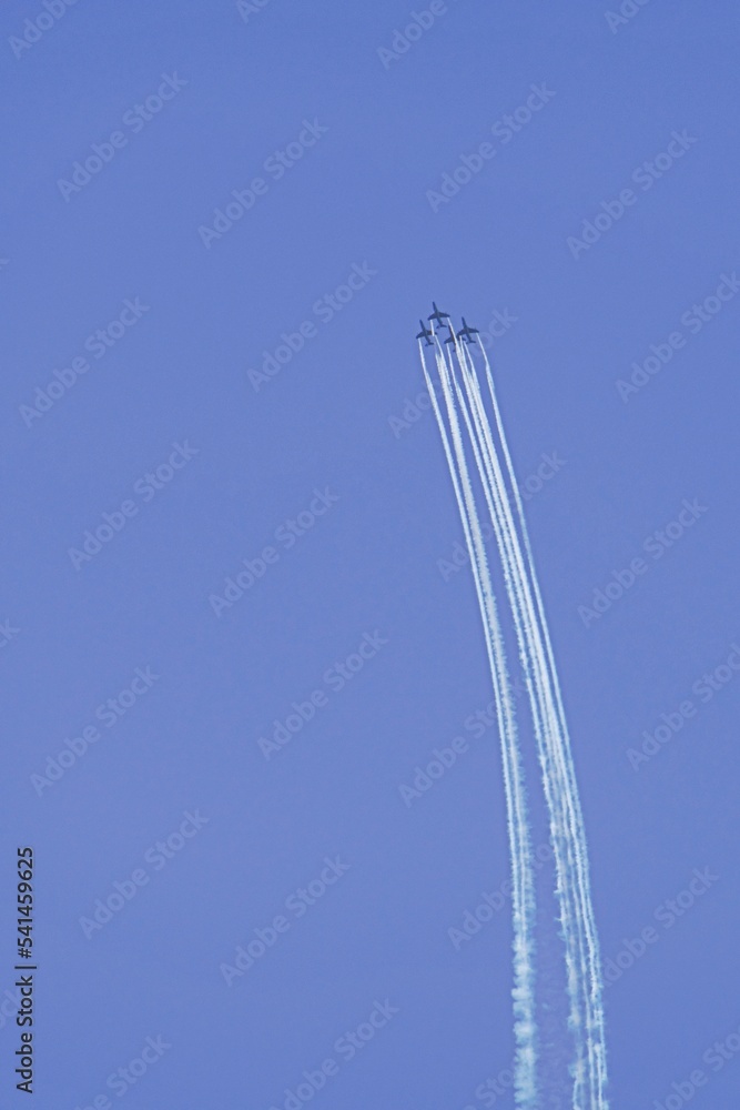 Flugzeug mit Kondensstreifen hoch am Himmel