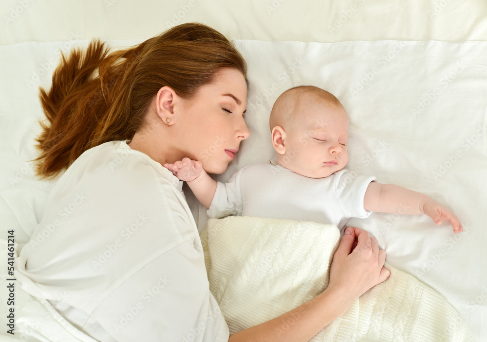 Young mother and her baby, sleeping in bed. Mother and baby. Happy family. Young mother and her baby, sleeping in bed. Mother and baby. Happy family.
