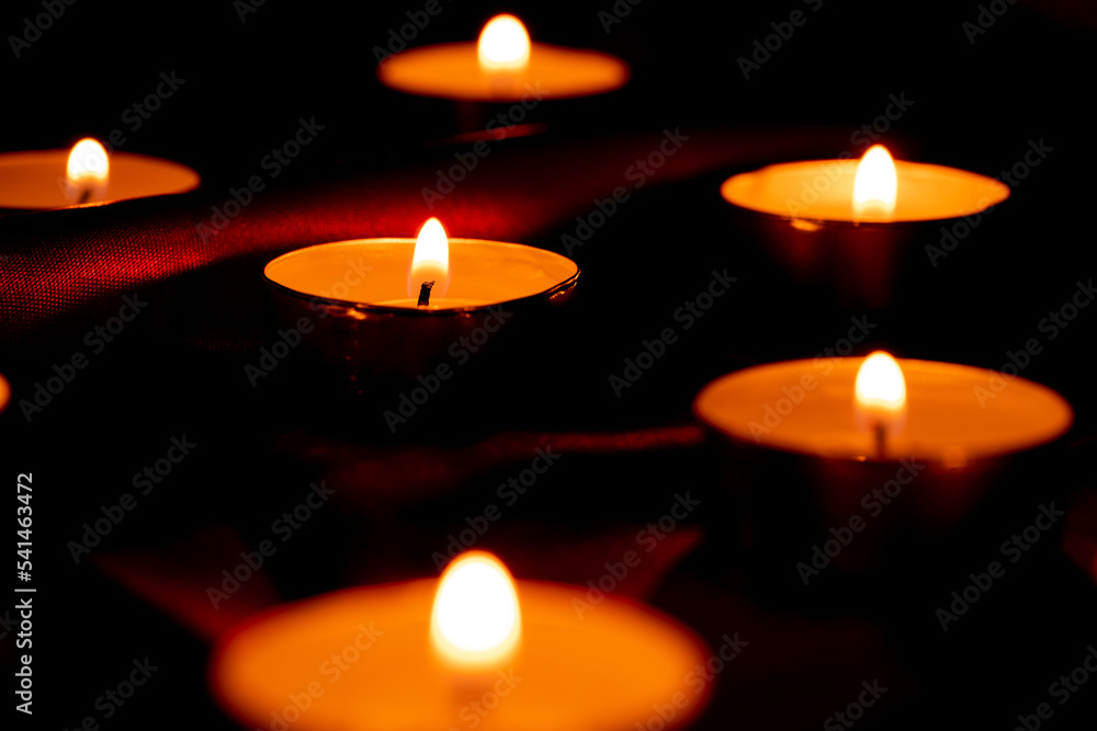 Candle light and red fabric background in the darkness with space for text or image. valentine love concept Candle light and red fabric background in the darkness with space for text or image. valentine love concept