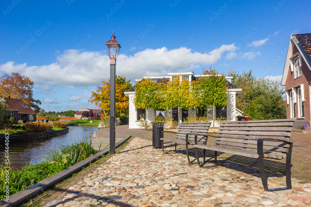 Wooden benches at the canal in historic village Kollum, Netherlands
