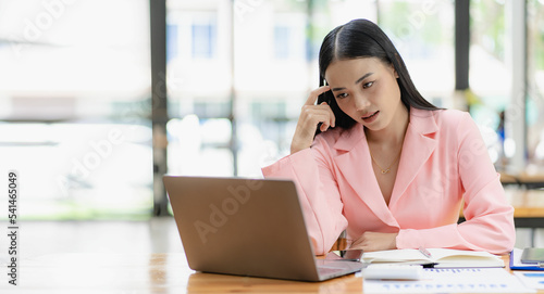 Wallpaper Mural 
Asian businesswoman analyzing a report pointing to a graph with a pen, laptop and calculator. In workstation accountant telemarketing concept, ecommerce, free online marketing. Torontodigital.ca