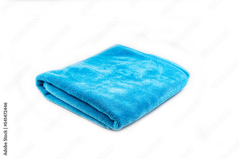 A blue microfiber cloth in two folded on white background A blue microfiber cloth in two folded on white background