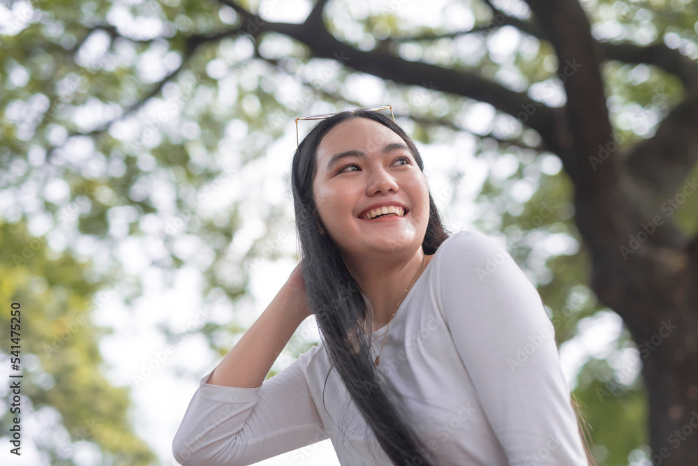 A low angle photograph of a beautiful Asian woman posing outside the park. A low angle photograph of a beautiful Asian woman posing outside the park.